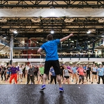 Staff member leading a group of students during a Zumba class